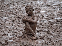 Chlapec z pedmstí pákistánského msta Láhaur se plácá v bahn u beh eky