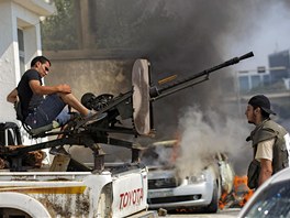 Libyjský povstalec zaujímá pozici, aby mohl pálit proti vládním vojákm (22.