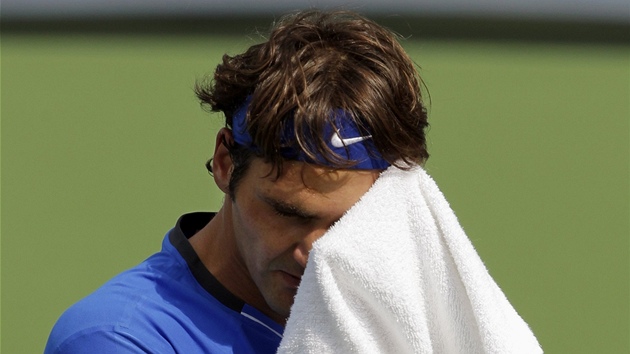 NA RUNÍK. výcar Roger Federer si utírá pot  z ela bhem zápasu s Tomáem