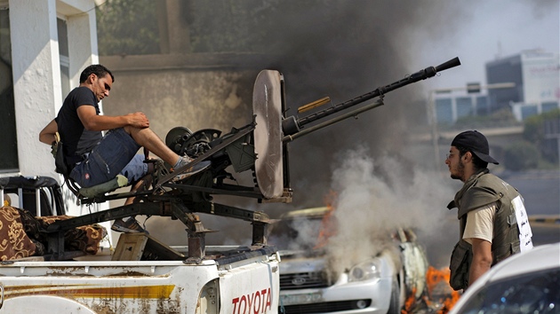 Libyjský povstalec zaujímá pozici, aby mohl pálit proti vládním vojákm (22.