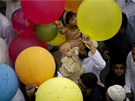 Svátek íd al-fitr je tídenním svátkem konce postního msíce ramadánu. Vtina muslim na celém svt ho zaala slavit v úterý. Na fotografii: Pákistánský muslim v Karáí kupuje po modlitbách v meit balónek svému malému synovi.