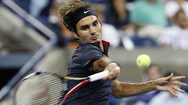 VIH. výcarský tenista Roger Federer pálí do míku bhem noního zápasu na US