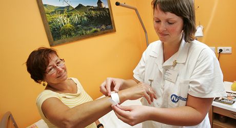 Sestra Miroslava Nedvdová nasazuje pacientce identifikaní náramek, který