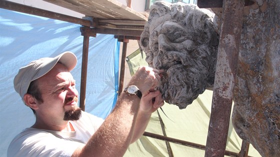 Obí atlanty nesoucí historický dm v Hraditi opravuje akademický socha