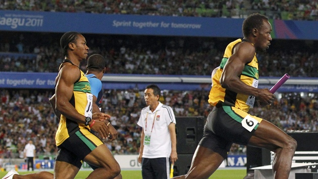 POSLEDNÍ PEDÁVKA. Usain Bolt pebírá tafetový kolík od Yohana Blakea a vyráí