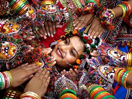 Indická dívka v tradiním rouchu taní spolu s dalími nazdobenými enami tanec