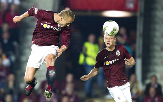 Poslední derby vyhráli sparané 3:0; do slávistické sít se hlavou práv trefuje Jií Jaroík (vlevo), sleduje ho Ladislav Krejí, autor druhé branky.