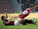  BUDE M. Ondej Petrk ze Slavie v souboji na zemi s Josefem Hubauerem ze