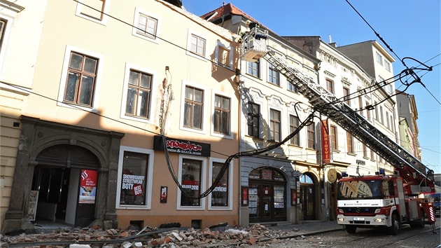 Hasii prohlíejí místo, kde se uvolnila ást falené títové zdi a zasypala chodník vetn procházející eny. Ta svým zranním na míst podlehla.