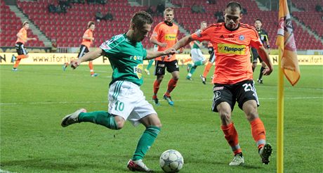 Záloník umský z Bohemians 1905 se snaí odcentrovat pes bránícího Vepeka z