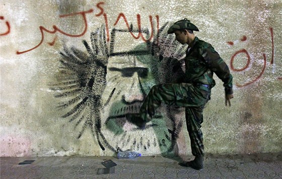 Libyjský voják Pechodné národní rady kope do zdi, na které je hanliv