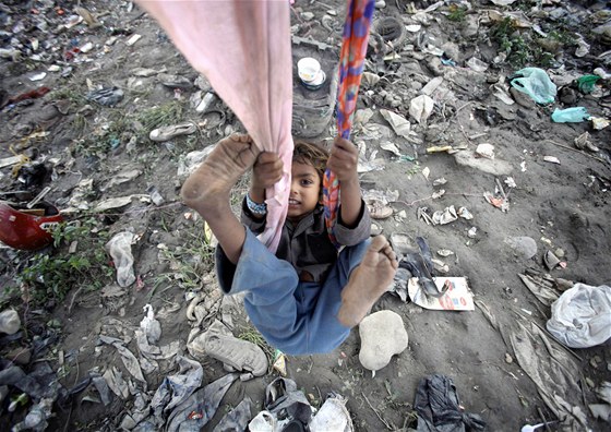 Nepálské dít dovádí na improvizované houpace v jednom ze slum Káthmandú....
