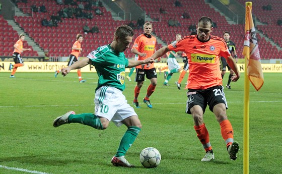 Záloník umský z Bohemians 1905 se snaí odcentrovat pes bránícího Vepeka z