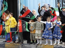 Libyjské eny a dti se radují a mávají královskými standartami. Slaví dobytí