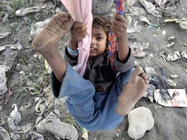 Nepálské dít dovádí na improvizované houpace v jednom ze slum Káthmandú....
