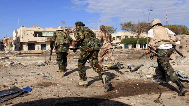 Vojáci libyjské Pechodné národní rady bí ulicí rozbombardovaného Kaddáfího rodit Syrtou. (19. íjna 2011)