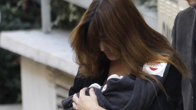 Carla Bruniová-Sarkozyová odchází s dcerou z porodnice (íjen 2010).