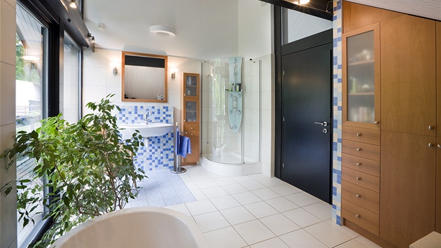 Koupelnu v podkroví osvil modrobílý mozaikový obklad a teplé tóny bukového