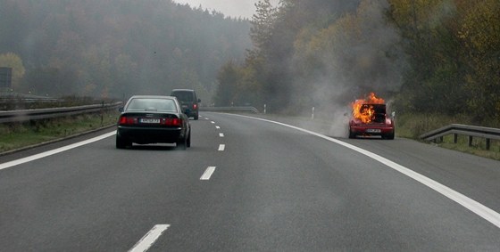 Hoící porsche v odstavném pruhu na dálnici A6 kousek za hraniním pechodem