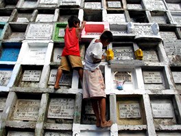 Filipíntí chlapci renovují a vymalovávají hrobky ped Duikami. Na Filipínách
