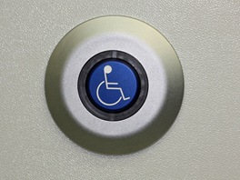 Tlaítko pro výstup cestujícího na vozíku je souástí sklopného sedadla.