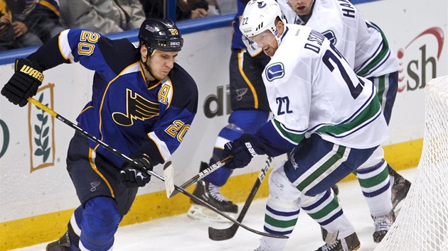 Obranu Vancouveru prohání  Alexander Steen (vlevo) ze St. Louis Blues. Hokejku