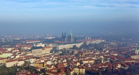 Praský hrad se koupe ve slunením svitu, zatímco zbytek Prahy zahaluje smog a