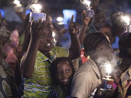Vící eny s lucernami taní ulicemi beninského msta Cotonou v pedveer