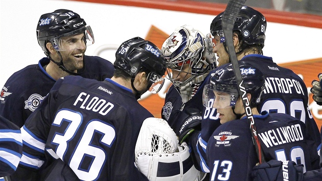 Hokejisté Winnipeg Jets slaví u svého brankáe Ondeje Pavelce výhru.