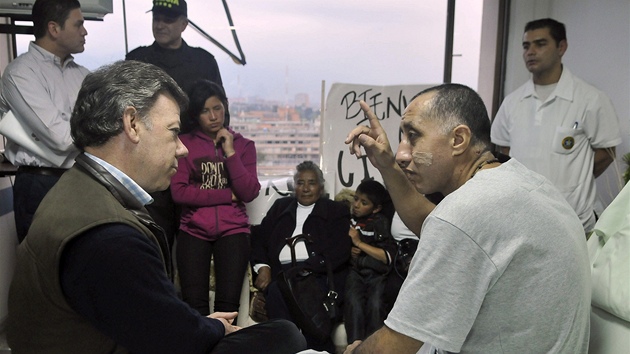 Kolumbijský prezident Juan Manuel Santos (vlevo) naslouchá policistovi a