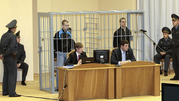 Dzmitryj Kanavalav (v kleci vlevo) a Uladzislav Kavaljov u soudu v MInsku (30.