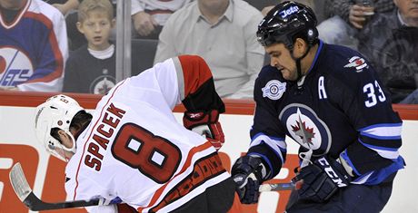 Jaroslav paek z Caroliny doluje puk ped Dustinem Byfuglienem z Winnipegu.