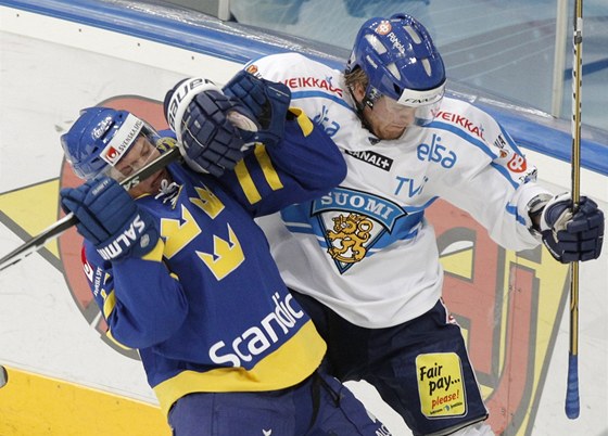 Patrik Zackrisson ze védska (vlevo) a Fin Janne Jalasvaara bojují u mantinelu
