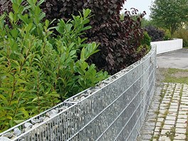 Úzký, mírn prohnutý gabion (15 cm) s betonovým základem. Gabiony se nejdív