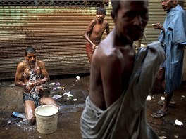 Indové za chladného rána provádjí hygienu v jedné z postranních uliek centra...