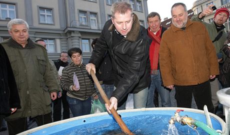 Ministr zemdlství Petr Bendl se snaí vylovit z kád kapra pi návtv v