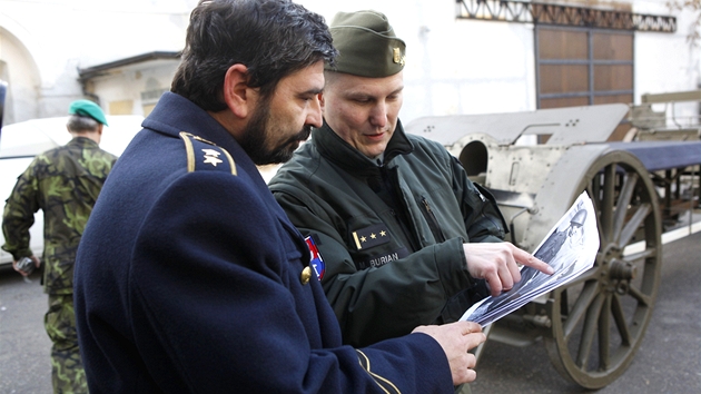 Michal Burian (vpravo) z Vojenskho historickho stavu stoj u historick lafety, kter vezla tak Masarykovy ostatky, a ukazuje historick fotografie (20. prosince 2011)