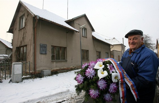 Lumír Horák dává kvtiny k domu Jana Palacha.