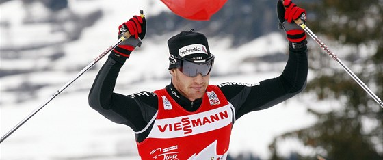 RUCE NAD HLAVOU. výcar Dario Cologna slaví vítzství v závodu Tour de Ski ve
