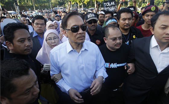 Anwar Ibrahim (uprosted ve sluneních brýlích) spolu s manelkou (za ním)