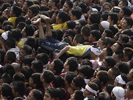 Filipínec se vrhá zpt do davu poté, co se mu podailo devnou sochu políbit...