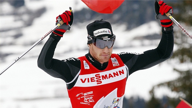RUCE NAD HLAVOU. vcar Dario Cologna slav vtzstv v zvodu Tour de Ski ve Val di Fiemme.