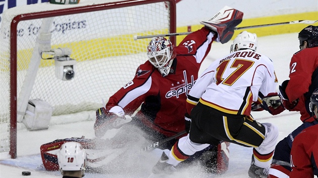 Washingtonský gólman Tomá Vokoun likviduje anci   Reneho Bourquea z Calgary.