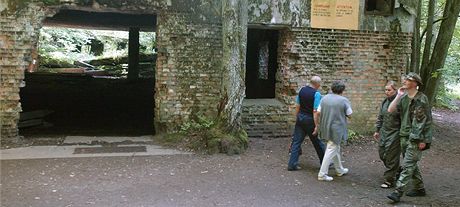 Turisté procházejí kolem trosek Vlího doupte u polského msta Gierlo.