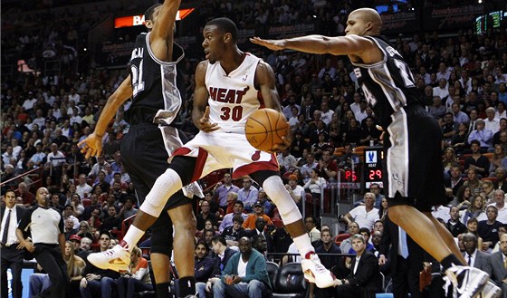 Norris Cole (uprosted) z Miami proti pesile v obsazení Tim Duncan (vlevo) a