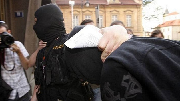 Policisté přivádějí neonacistu k výslechu. Policisté přivádějí neonacistu k výslechu.