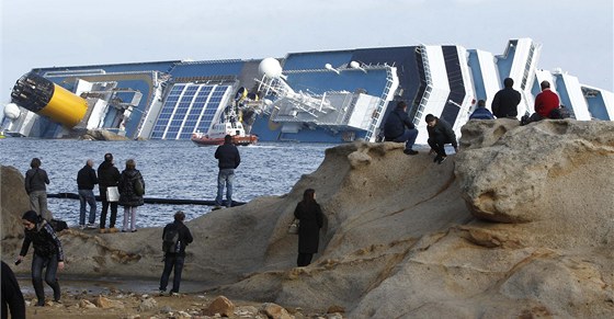 Zvdavci okukují vrak lodi Costa Concordia, která ztroskotala u italského