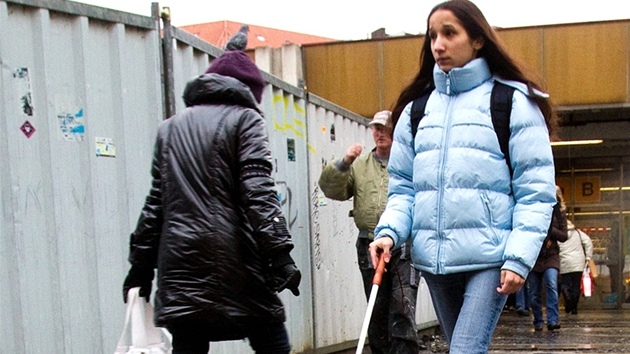 Nevidomá dívka klopýtá rozbitým chodníkem u metra Národní tída.