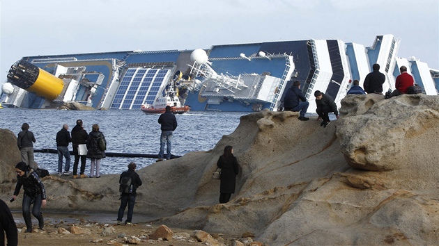 Zvdavci okukují vrak lodi Costa Concordia, která ztroskotala u italského