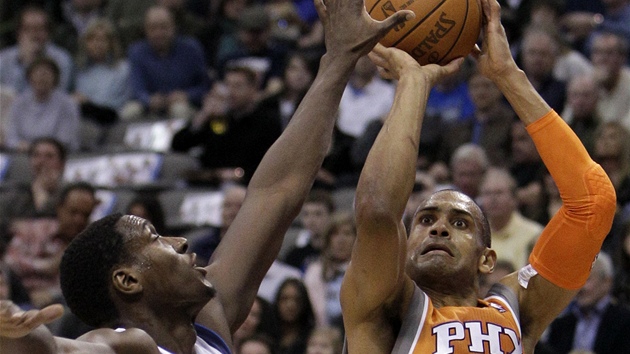 Grant Hill (vpravo) z Phoenixu stílí pes Iana Mahinmiho z Dallasu.